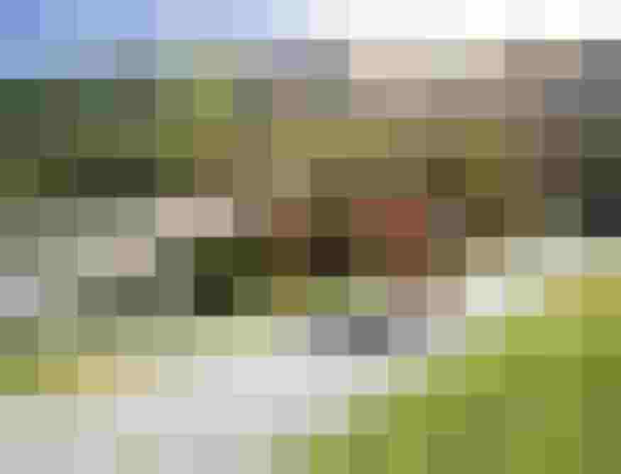 Gruppe Wandernder auf einem Schotterweg neben einer Hängebrücke in alpiner Berglandschaft